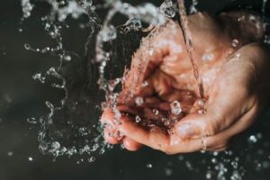 Hands being cleaned by clean water from a PFAB and microplastic water filter installed in a Naples home.