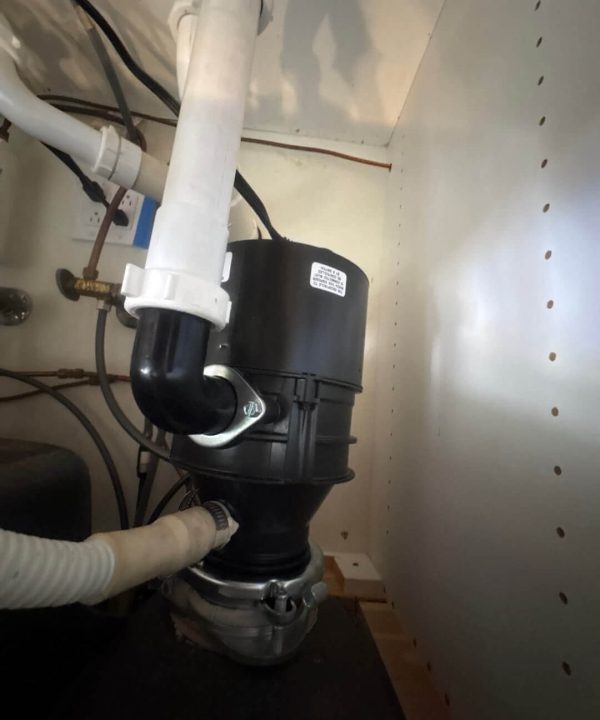 Garbage disposal system installed under kitchen sink in Naples, Florida home by a professional plumber.